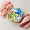 Flat-lay 200064a CATY Kuřecí & kachní paštika 100 g se syrovým kuřecím a kachním masem na světlé kuchyňské lince.