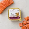 Flat-lay 20006 FIRST CLASS Losos paštika 100 g se syrovým lososem na světlé kuchyňské lince. Label ref = BaseLinker packshot 620 px.
