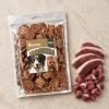 Flat-lay Masíčka 204863 (režim Produkt + suroviny): plný 300g sáček dle e-shop packshotu 1f2a6243, syrové kachní maso asymetricky, travertin, evergreen. Reference surovin AI-generovaná (HF job 20cf295c, 2,75 cr).