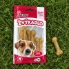 Flat-lay shora na trávě: sáček Žvýkadlo PAPKY se 3 buvolími kostmi 8 cm (204048) a vedle volně ležící jedna kost.