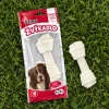 Flat-lay shora na zelené trávě: sáček bílého uzlu z buvolí kůže 204051 leží naplocho, vedle jeden volný bílý uzel 15 cm. Přirozené denní světlo, fotorealistické.