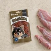 Flat-lay pro řadu Masíčka (SKU 216690) – travertin, sáček mírně mimo střed a pootočený, pouze syrové králičí maso (hřbet, pruhy) asymetricky v jednom rohu. Styl sjednocen s flat-layem 216689 (asset 7817).
