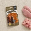 Flat-lay pro řadu Masíčka (SKU 204813) – travertin, sáček mírně mimo střed, pouze syrové kuřecí maso (2 prsní filety + plátky) asymetricky v jednom rohu. Styl sjednocen s flat-layi 216689/216690.