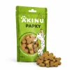 Packshot se surovinou Akinu PAPKY Kostička žlutá pamlsek pro psy 100 g (174027) — obal natočený podle vzoru 174027, vpravo dole před ním hromádka pamlsku. Styl jako řada Masíčka Premium.