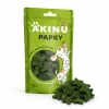 Packshot se surovinou Akinu PAPKY Hvězda zelená pamlsek pro psy 100 g (174031) — obal natočený podle vzoru 174027, vpravo dole před ním hromádka pamlsku. Styl jako řada Masíčka Premium.