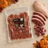Flat-lay Masíčka 204945 (666 g, Halloween edice): plný sáček dle packshotu abb62b61, pouze syrové kachní maso asymetricky v jednom rohu, travertin, podzimní/halloweenský styling (mini dýně, listí, kaštany). Kompozice dle flat-laye 276faa55. Reference surovin AI-generovaná (HF job 41145f0b, 2,75 cr). Vybrána v1 ze 2.