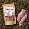 Flat-lay Králík jerky 176304 – sáček + syrové králičí maso na lesním jehličí.