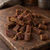 Solo surovina Akinu MASÍČKA Jehňečí kousky 300 g (282061) — hromádka na tmavém prkénku. Reference suroviny převzata z 204815 (přebalovaný produkt, potvrzeno uživatelkou) — 282061 nemá v Heliosu štítek Surovina.